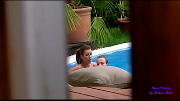 Two friends touch and lick each other in the pool, while another girl spies on them