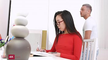 Russian girl Li Loo with oriental features tries to do homework as a good student